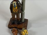 a figurine of a man holding a bottle opener and a bottle opener