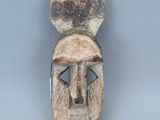 une image représentant un masque en bois sur lequel figure un visage