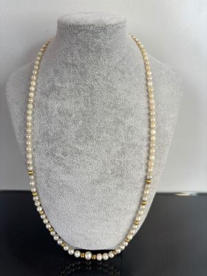 a necklace with pearls and gold beads on a mannequin