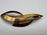 an image of a gold broochle on a white surface