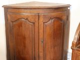 a corner cabinet in the corner of a room