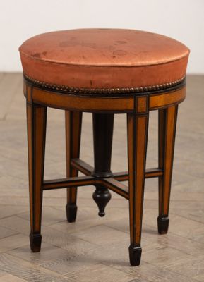 une image représentant un petit tabouret en bois avec une assise en cuir