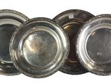four silver plates are stacked on top of each other