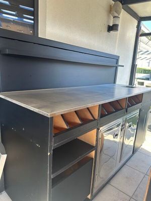 une cuisine d'extérieur avec un barbecue encastré dans le mur