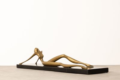 bronze sculpture of a woman laying on a black base