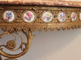 a gold table with a marble top and a gold base