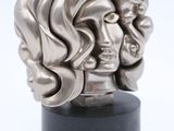 a silver sculpture of a woman ' s head on a black stand