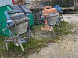 two old cement mixers on the side of the road