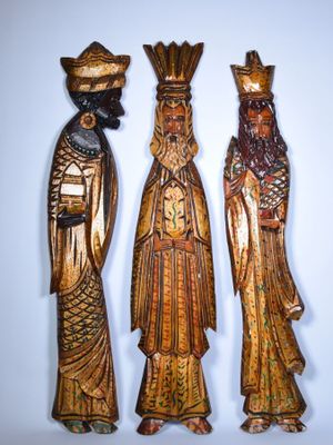 trois figurines en bois représentant trois hommes portant un chapeau et une barbe