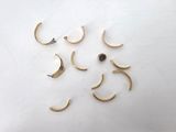 six pairs of gold hoop earrings on a white surface