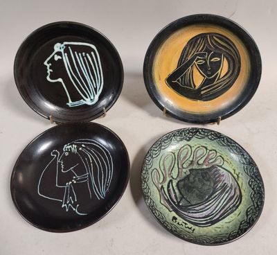 three black and yellow plates with drawings on them sitting on a table