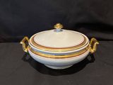 a close up of a white bowl with gold trim on a black background