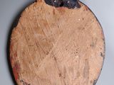 a wooden plate with a metal handle hanging on a wall
