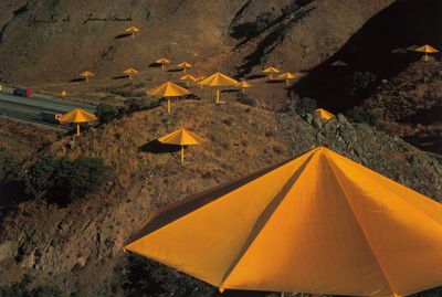 many yellow umbrellas that are on the side of a hill
