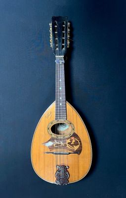 a guitar hanging on a wall with a blue background