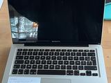 a laptop computer sitting on a table with a notepad