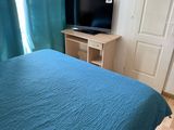 un lit avec une couette bleue et une télévision à écran plat dans un coin