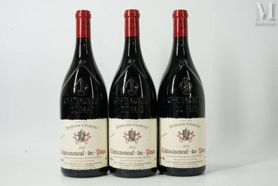 trois bouteilles de vin rouge posées sur une table blanche
