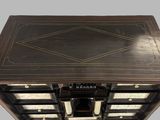 a black and gold chest of drawers with a clock on top