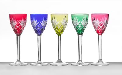 quatre verres à vin de couleurs différentes sont alignés en rangée