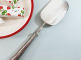 a plate with a piece of cake on it next to a spoon