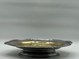 a silver plate on a white table with a white background