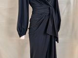 La robe est noire et a des manches longues.