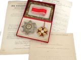 une petite boîte contenant une médaille et sur laquelle est posée une médaille