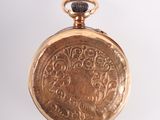 an old gold pocket watch on a white surface with a white background