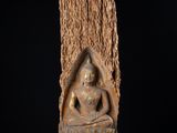 une image représentant une statue de Bouddha assis sur une souche d'arbre
