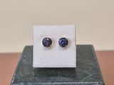 une paire de boucles d'oreilles en saphir bleu posées sur un bloc de marbre