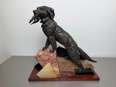 statue of a dog sitting on a block of cheese with a piece of cheese in its mouth