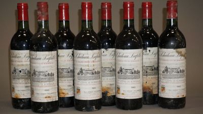 six bouteilles de vin sont alignées sur une table