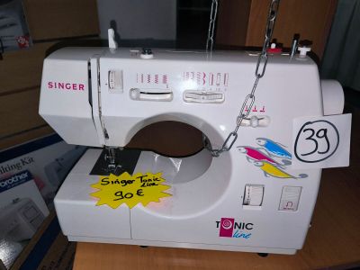 a white sewing machine with stickers on it sitting on a table