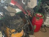 a pile of assorted items on a shelf in a garage