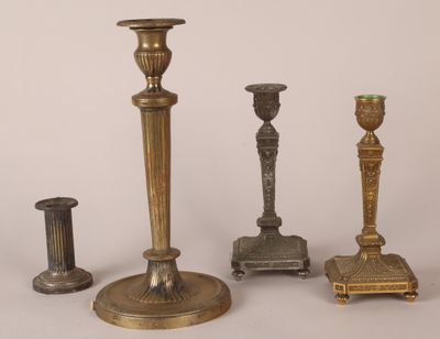 several different types of brass candlesticks on a white background