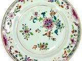 a plate with a floral design on it on a white surface
