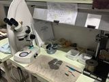 un microscope dans une pièce où la table est encombrée d'objets