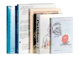 plusieurs livres sont empilés sur une surface blanche