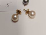 two pairs of pearl and gold earrings on a white surface