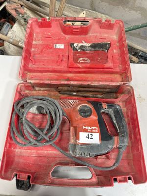 une boîte à outils rouge contenant une perceuse filaire