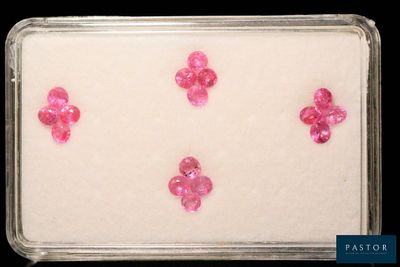 quatre diamants roses sont disposés dans un plateau posé sur une surface noire