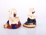 two figurines of a man and a woman sitting on top of each other