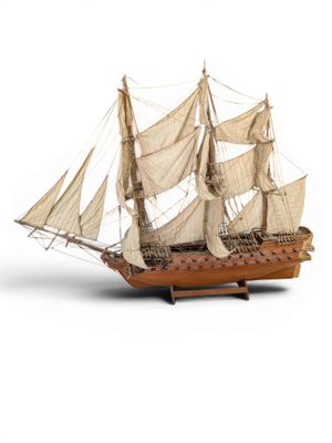 a small model of a sailboat on a white surface