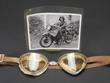 a picture of a pair of goggles with a picture of a man on a motorcycle in the background