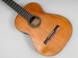 an image of a guitar with a wooden body and a leather strap