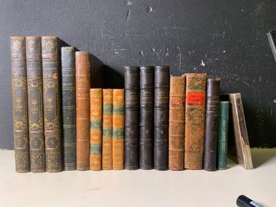 de nombreux livres anciens alignés sur une étagère à côté d'un téléphone portable