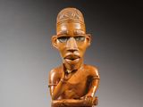 une statue en bois d'un homme avec un chapeau sur la tête