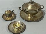 a silver plate with a silver cup and saucer on it