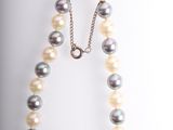 a white and black pearl necklace with a gold clasp